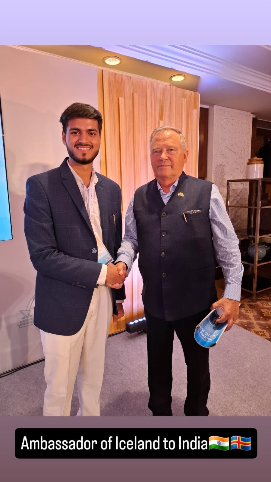 Akshat Mehrotra shaking hands with the Ambassador of Iceland to India.